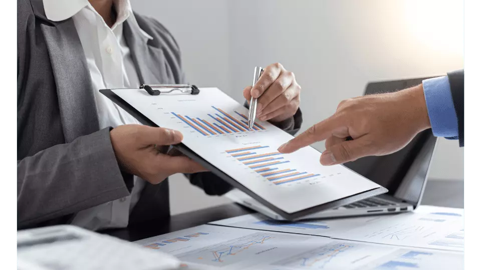 business peoples hands holding a graph on a clipboard
